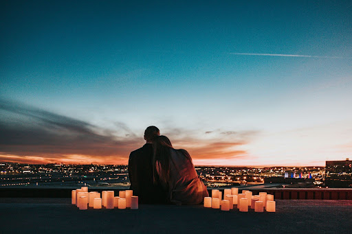 Couple sitting together and looking out into the sunset.