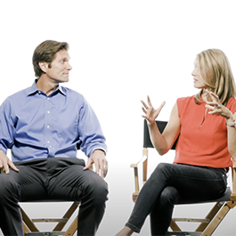 video screenshot of two people sitting and talking